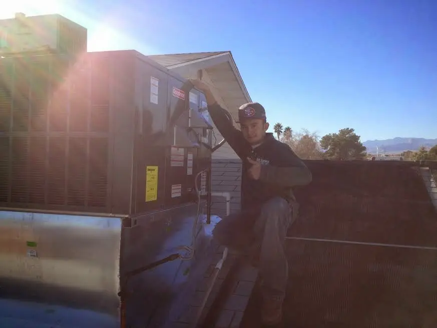 HVAC technician performing HVAC Inspection on a rooftop unit in Highland Lakes